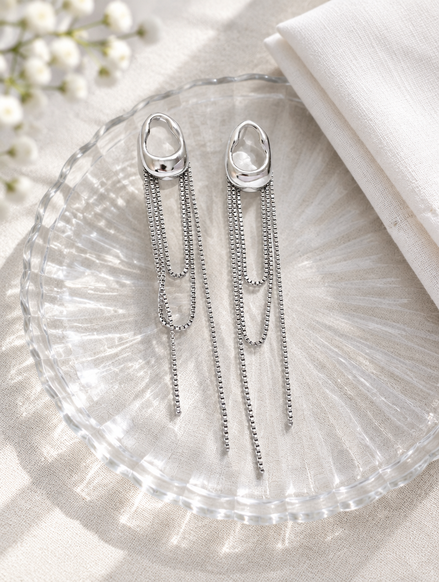 Silver chain tassel drop earrings with pearl-look bead in a styled still life with props