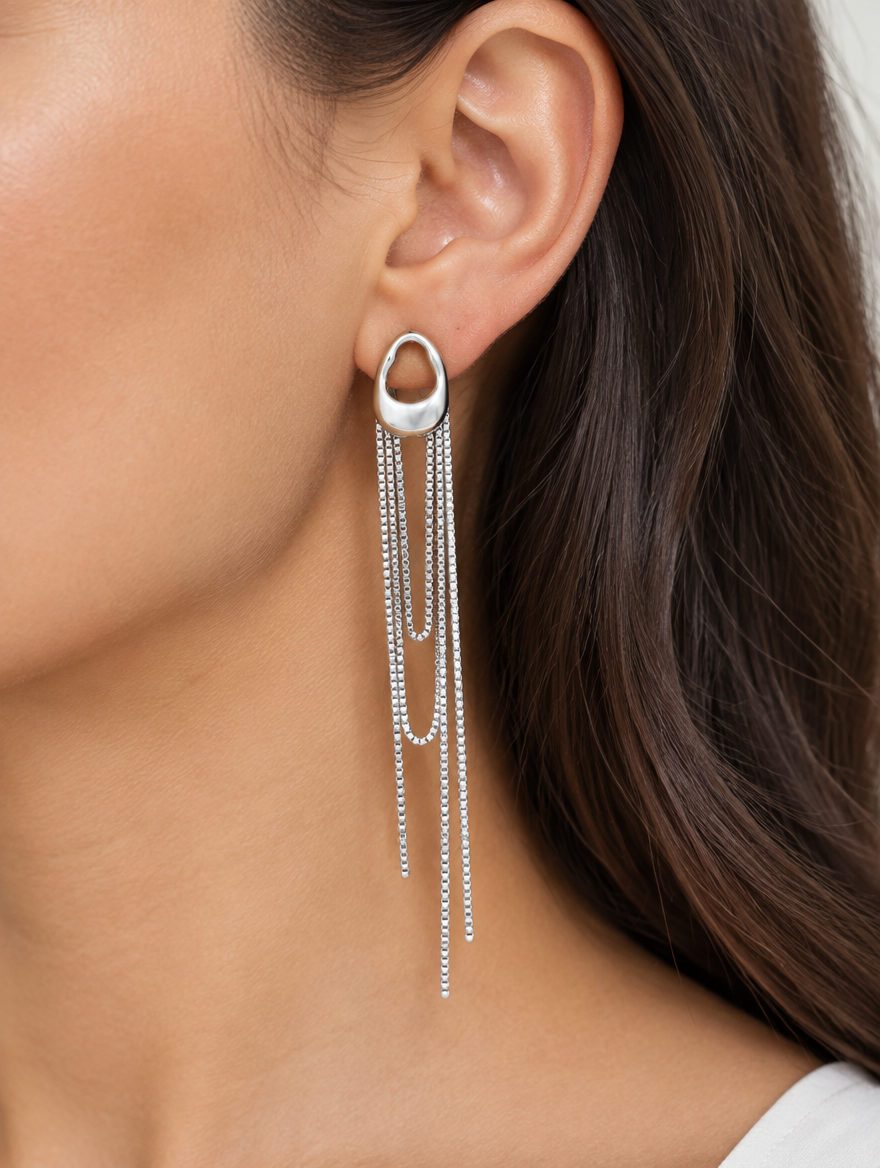 Woman wearing a silver chain tassel drop earring with pearl-look bead