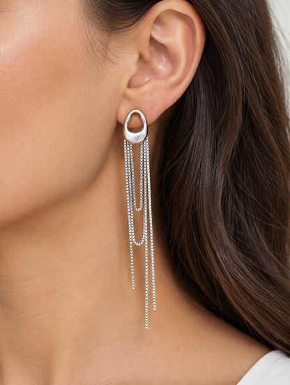 Woman wearing a silver chain tassel drop earring with pearl-look bead