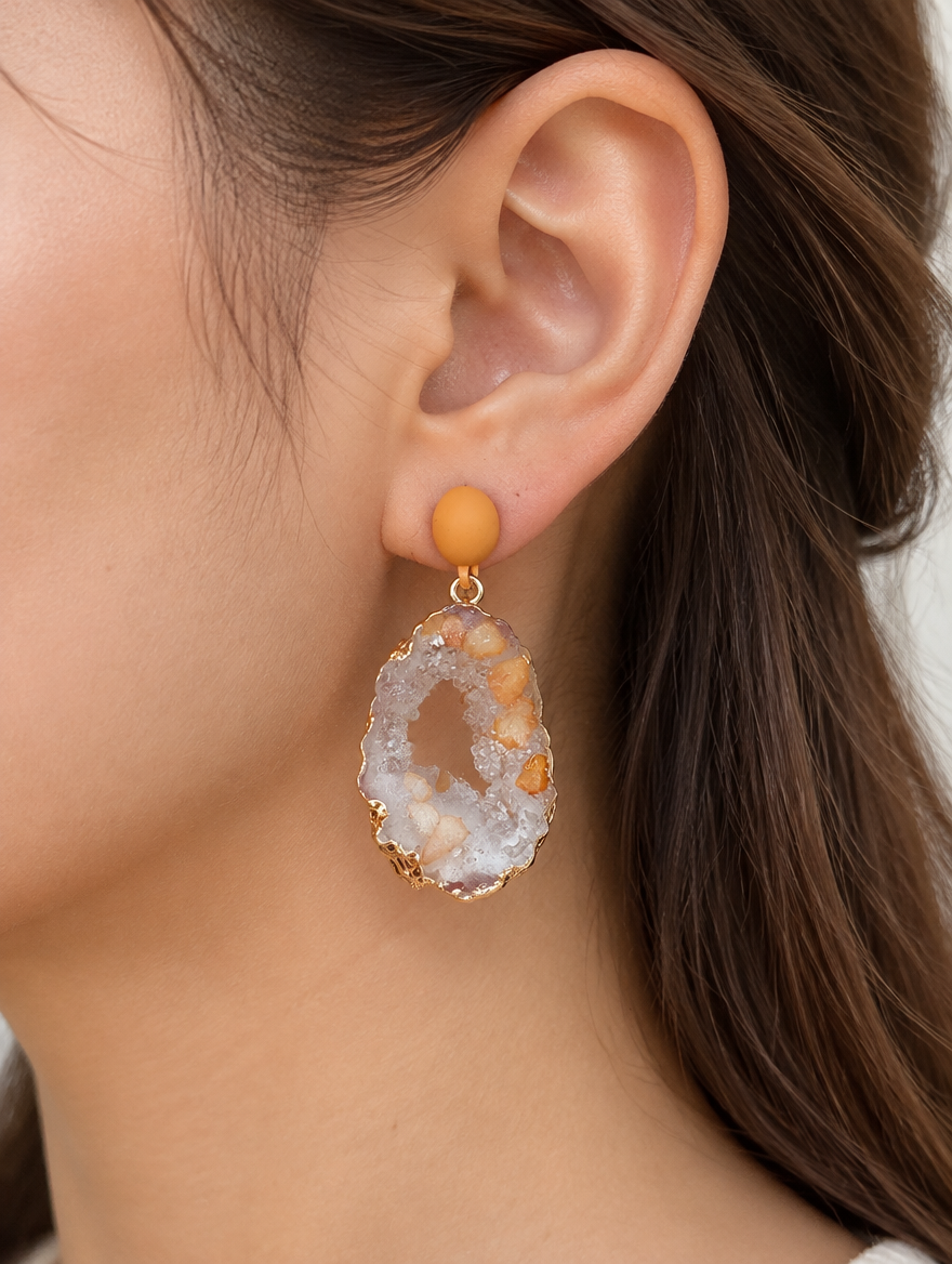 Woman wearing a orange stone-look drop earring with gold-tone edge