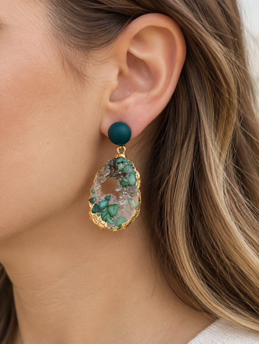 Woman wearing a green stone-look drop earring with gold-tone edge