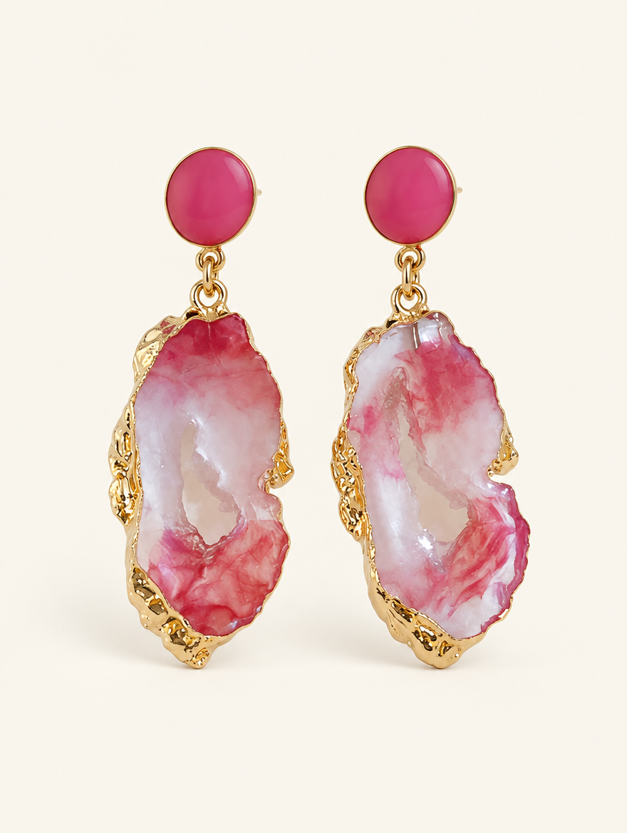 Pair of pink stone-look drop earrings with gold-tone edge on a warm off-white background