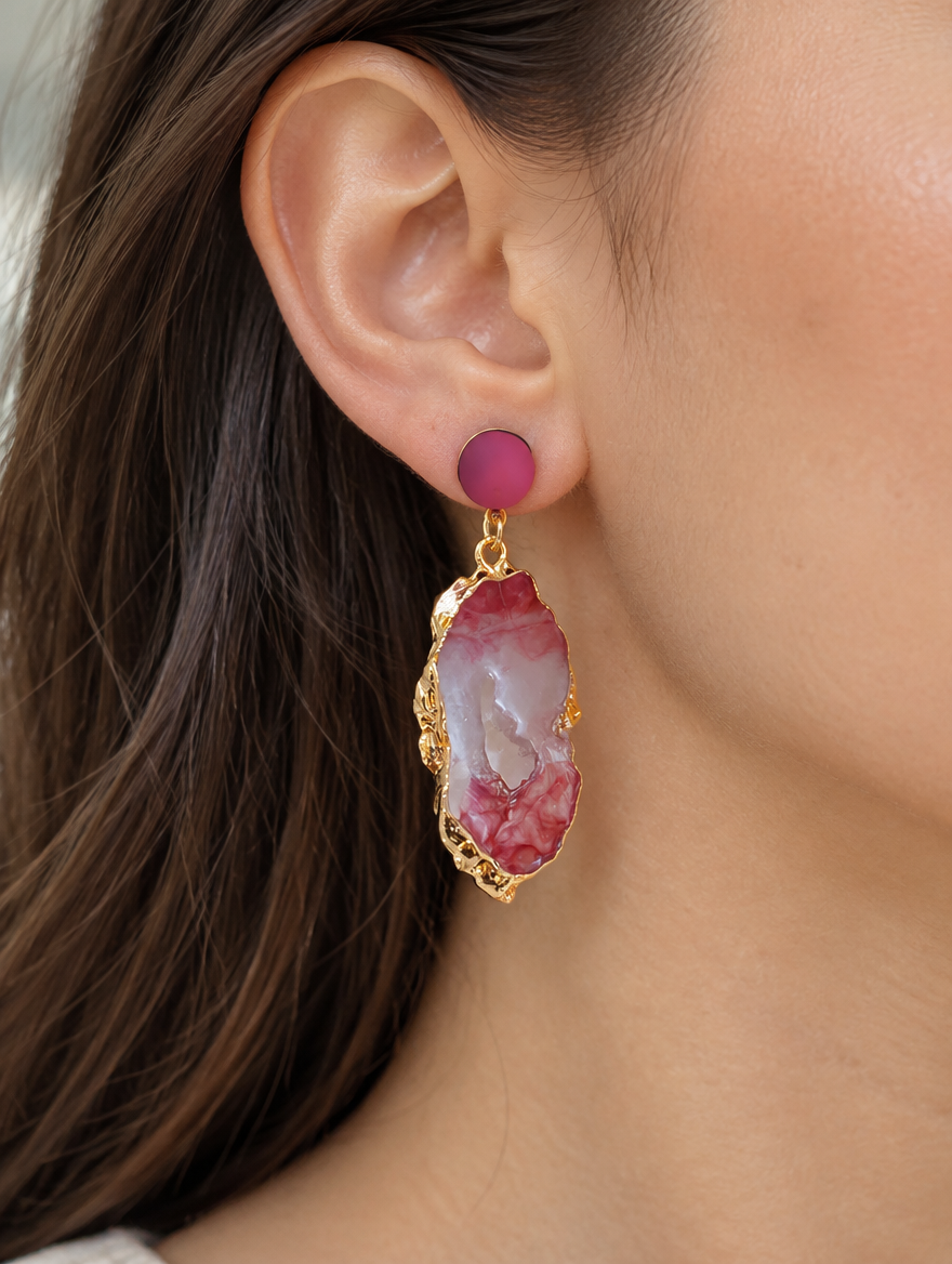 Woman wearing a pink stone-look drop earring with gold-tone edge