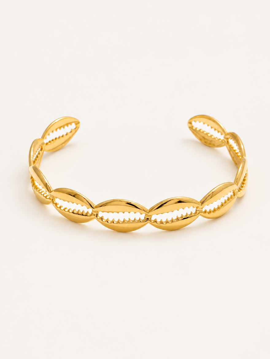 Gold hollow shell open cuff bracelet on a neutral background