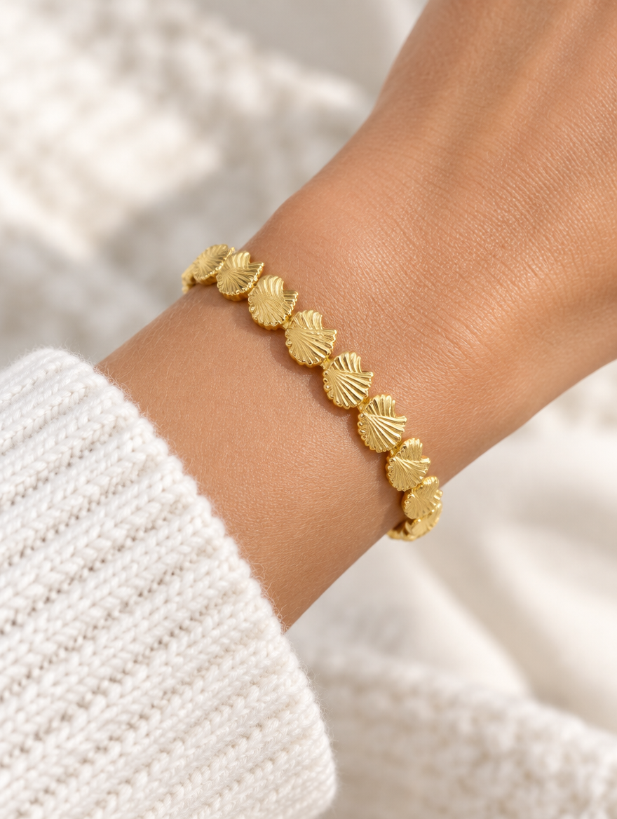 Woman wearing a gold scallop shell open cuff bracelet
