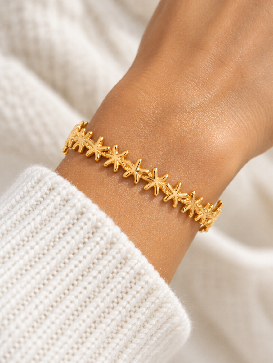 Woman wearing a gold starfish open cuff bracelet