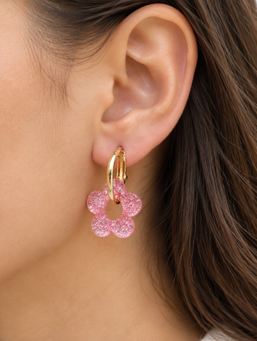 Woman wearing a gold-tone flower huggie hoop earring