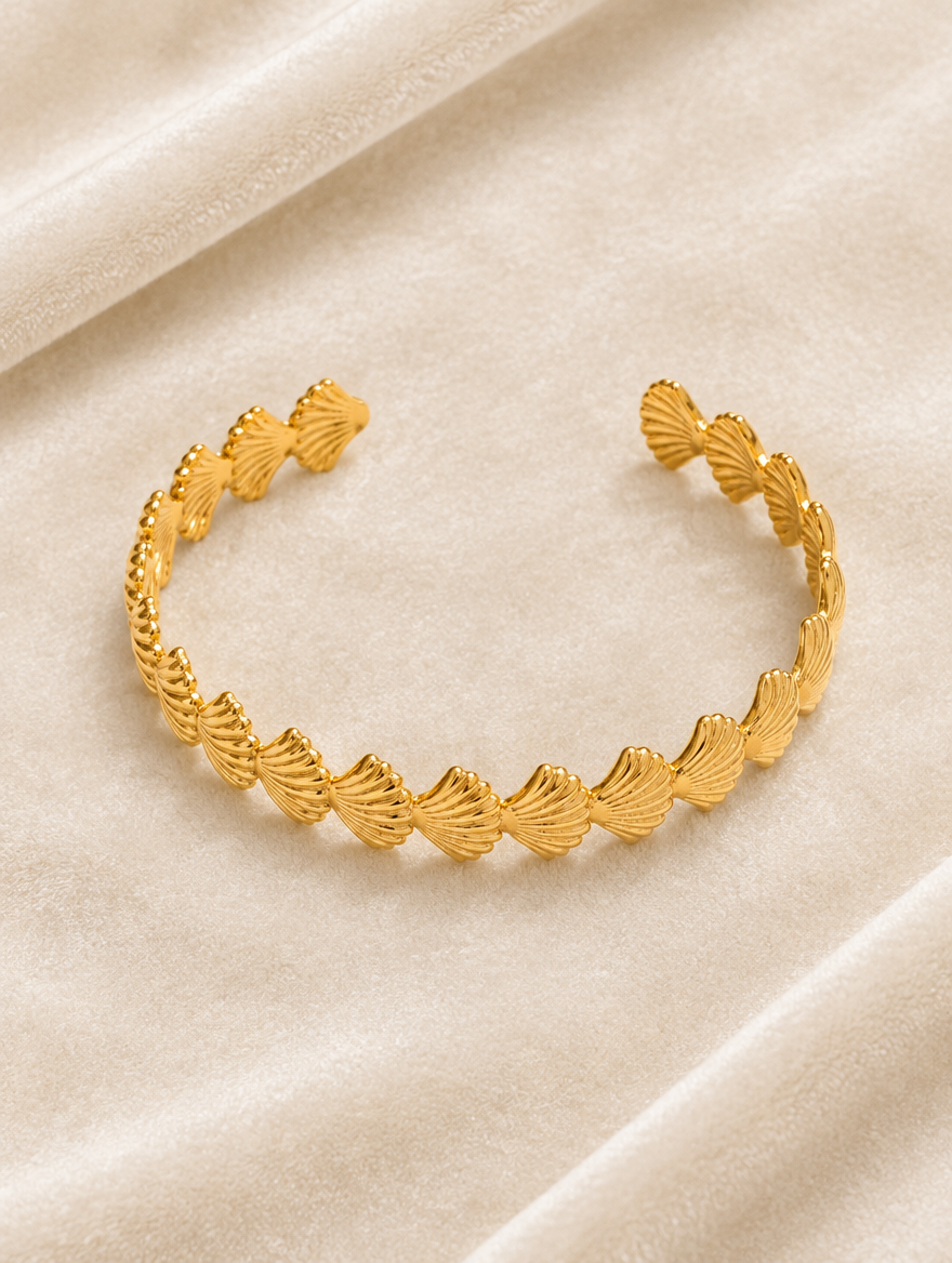 Gold scallop shell cuff bracelet on cream velvet