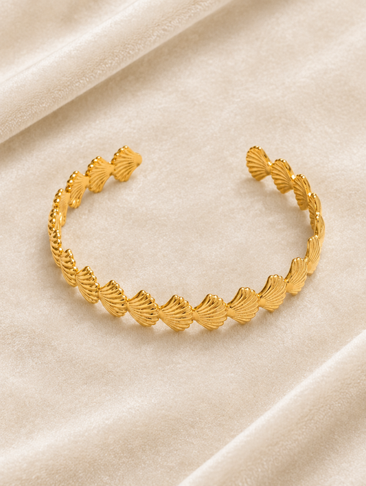 Gold scallop shell cuff bracelet on cream velvet