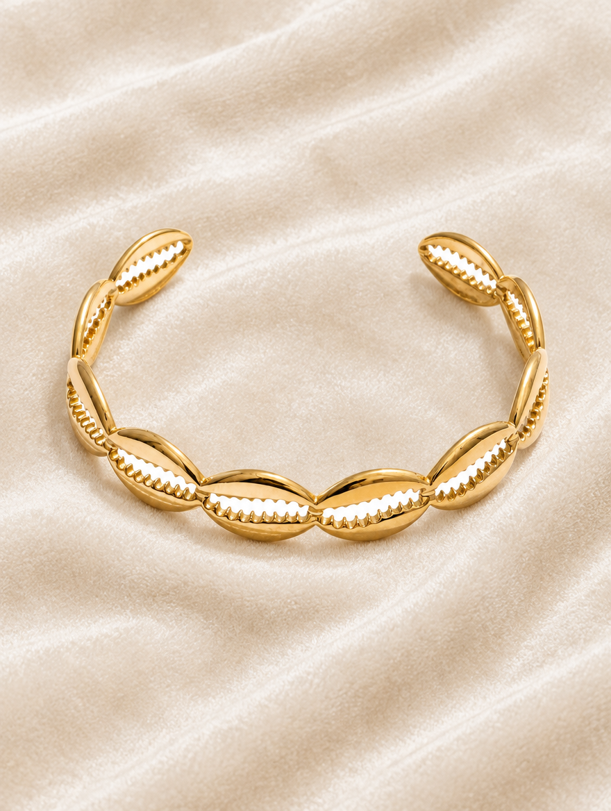 Gold hollow shell cuff bracelet on cream velvet