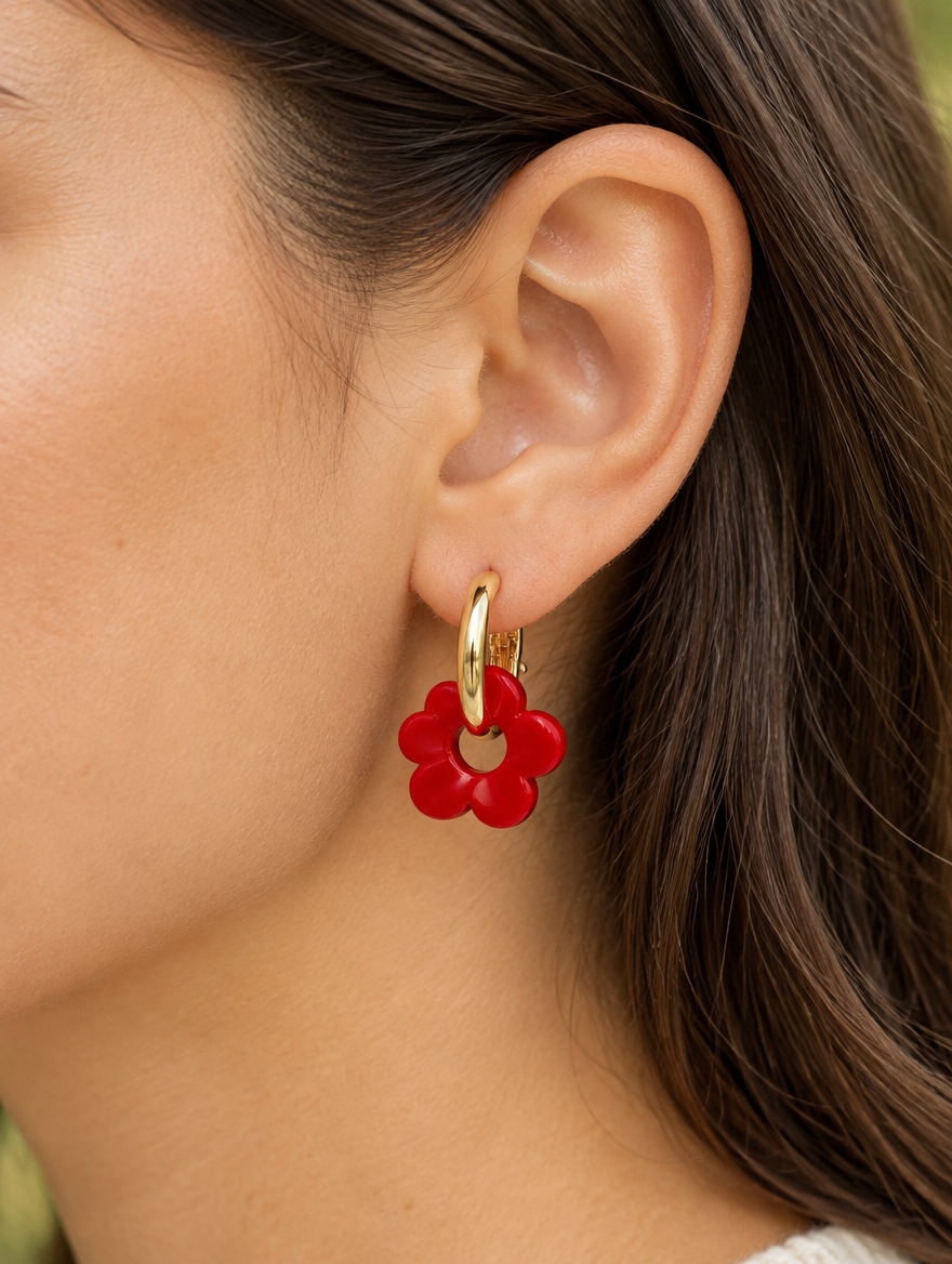Woman wearing a gold-tone flower huggie hoop earring