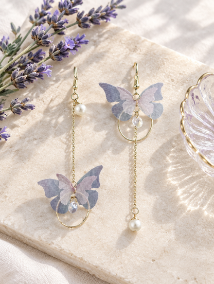 Lilac butterfly chain drop earrings in a styled still life with props