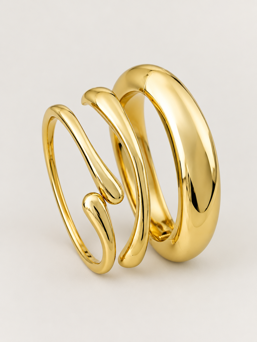 Set of three gold-tone open bangles on a neutral background