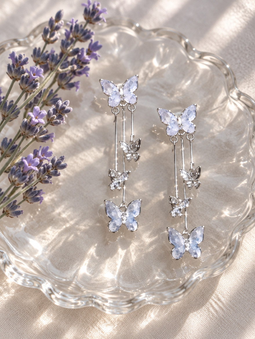 Silver-lilac butterfly tassel drop earrings in a styled still life with props
