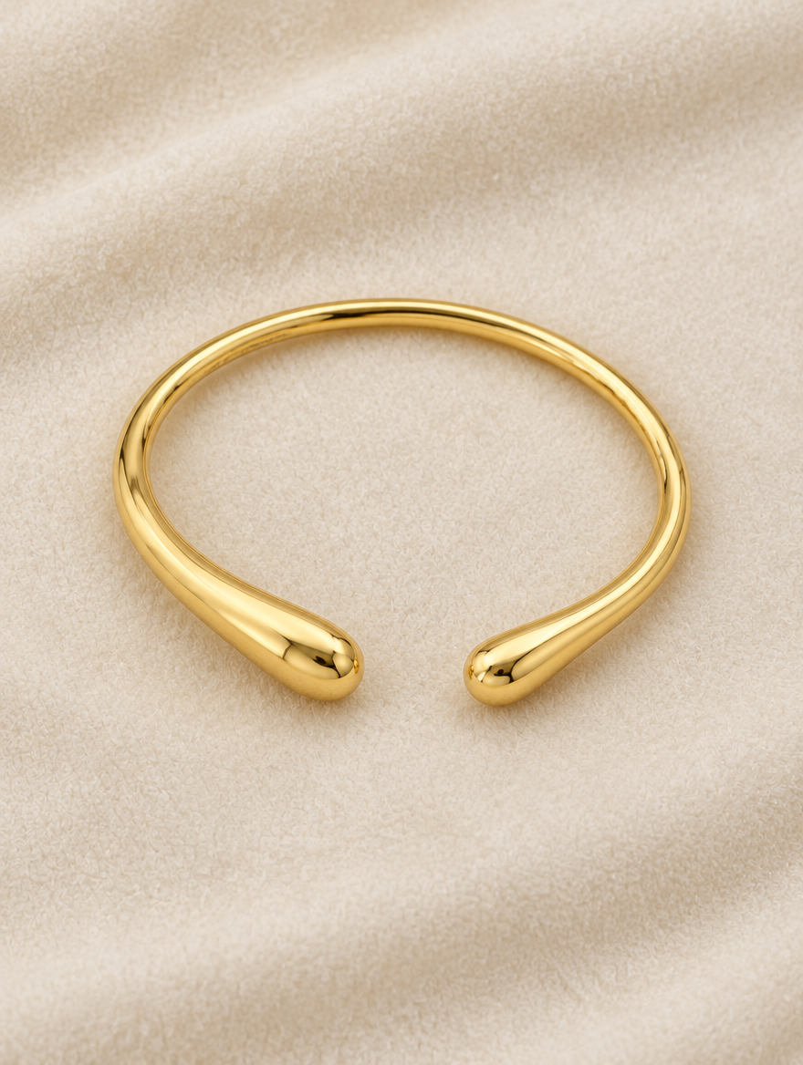 Slim gold-tone teardrop cuff on cream velvet