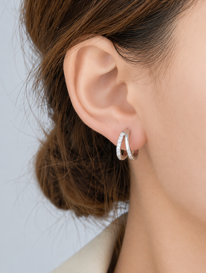 Woman wearing a silver double-ring CZ huggie hoop earring