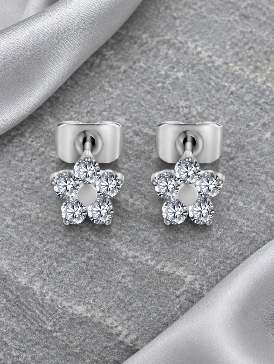 Titanium CZ flower stud earrings lying flat on a soft styled surface