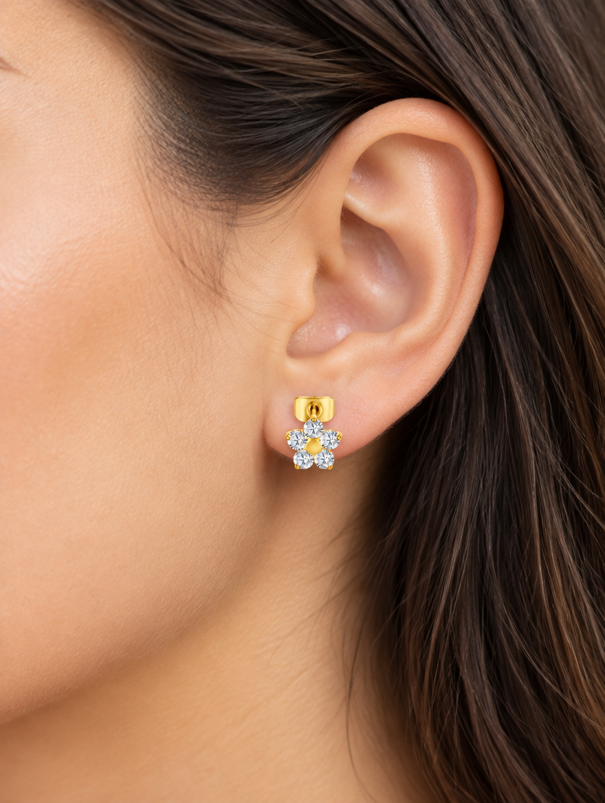 Woman wearing a gold titanium CZ flower stud earring