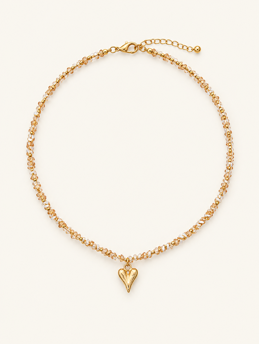 Champagne bead choker necklace with a small gold-tone heart pendant on a neutral background