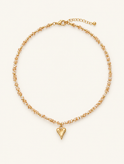 Champagne bead choker necklace with a small gold-tone heart pendant on a neutral background