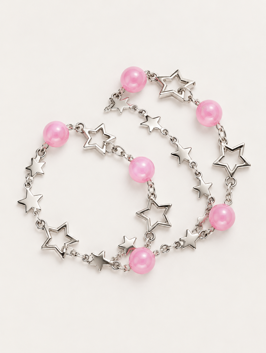 Silver-tone star chain bracelet set with pink beads on a neutral background