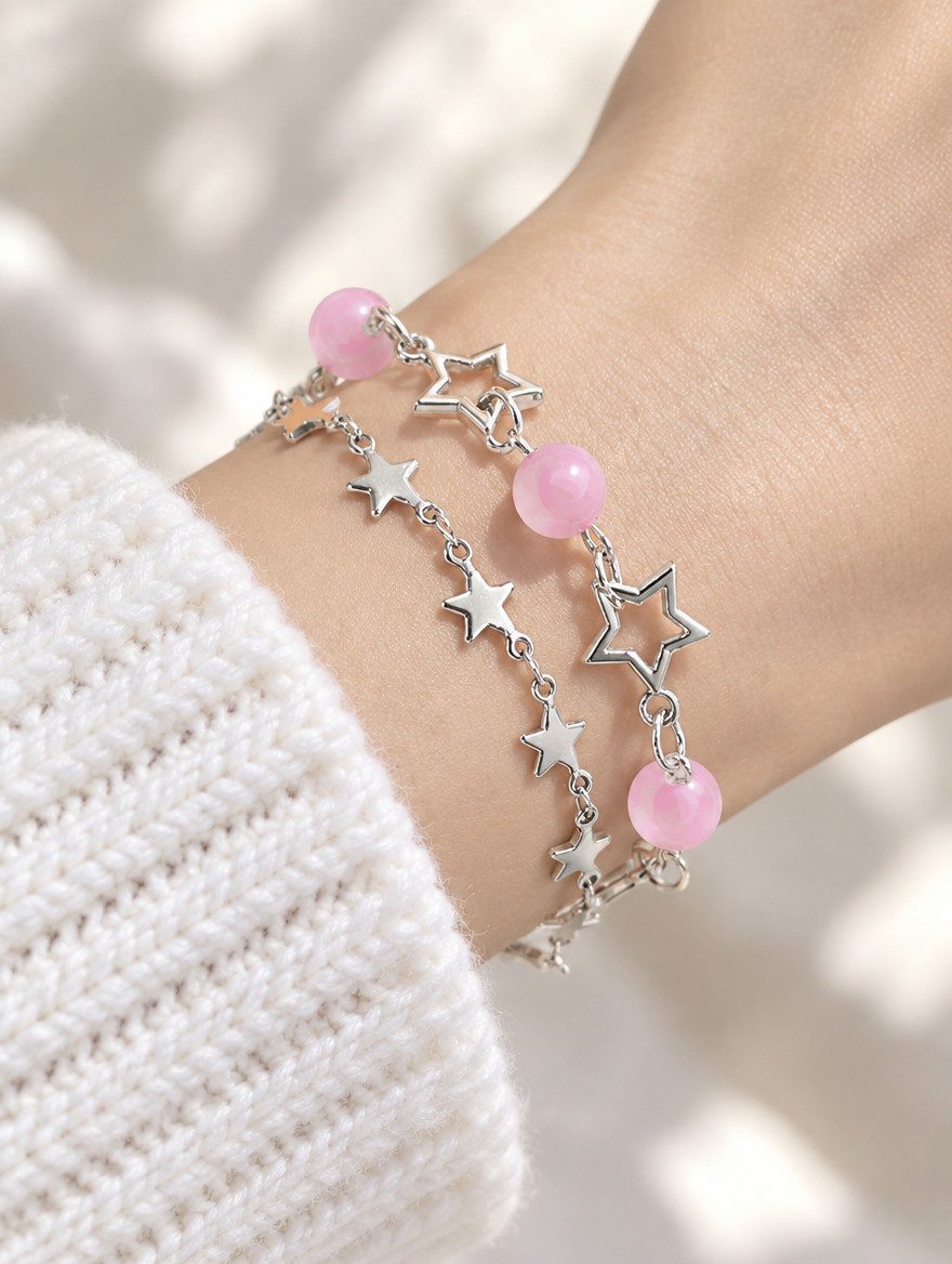 Woman wearing silver-tone star chain bracelets with pink beads