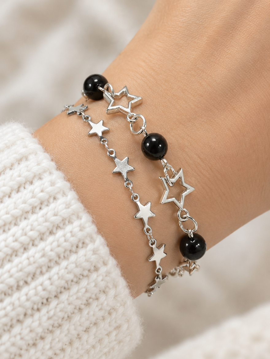 Woman wearing silver-tone star chain bracelets with black beads