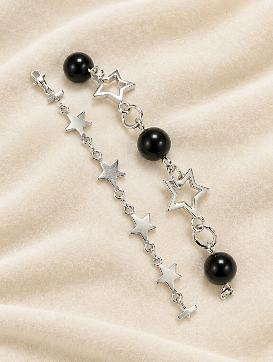 Star chain bracelets with black beads on cream velvet