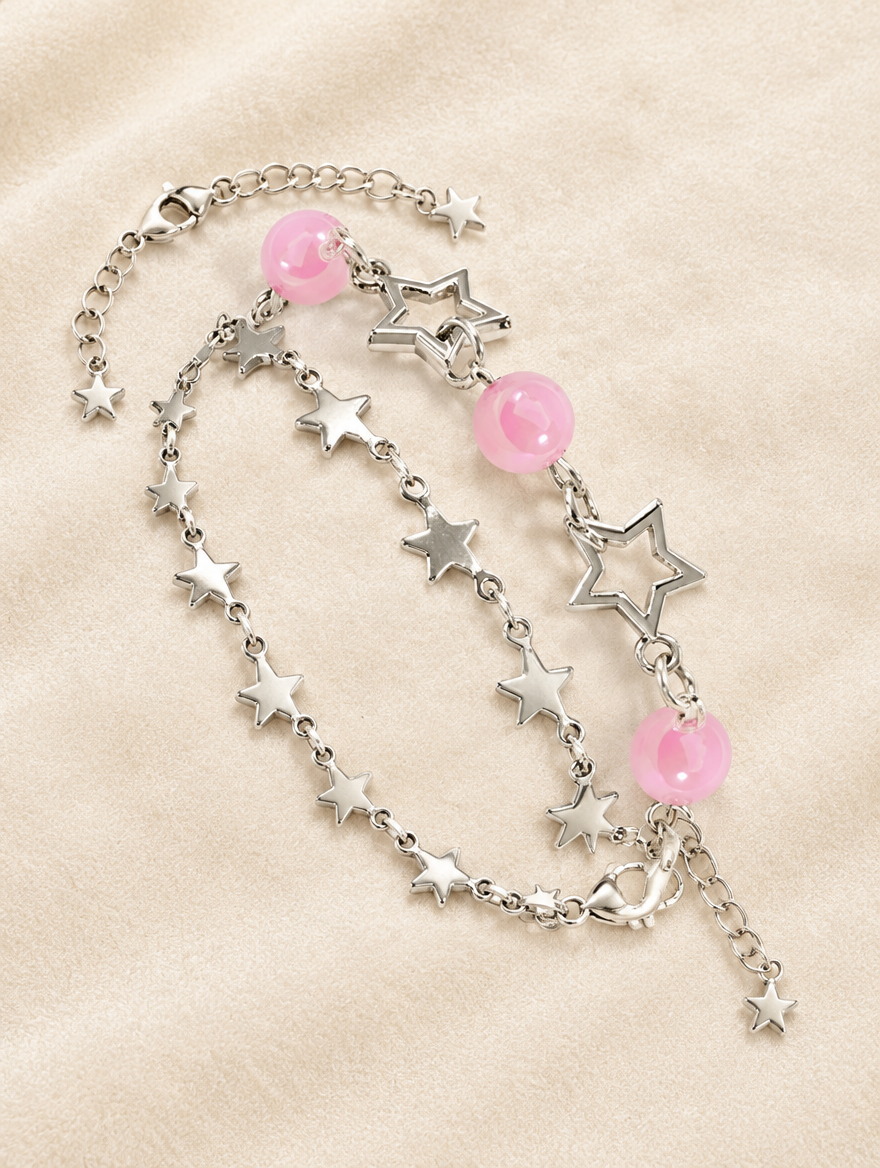 Star chain bracelets with pink beads on cream velvet