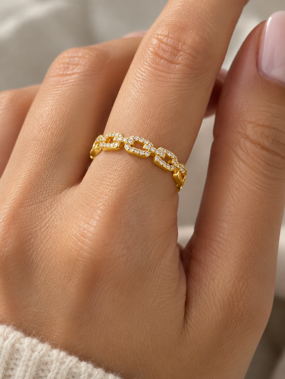 Woman wearing a gold slim chain link zirconia ring on her finger