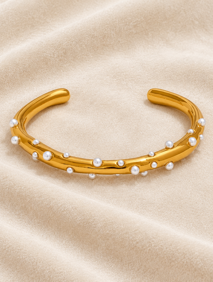 Gold pearl cuff bracelet on cream velvet