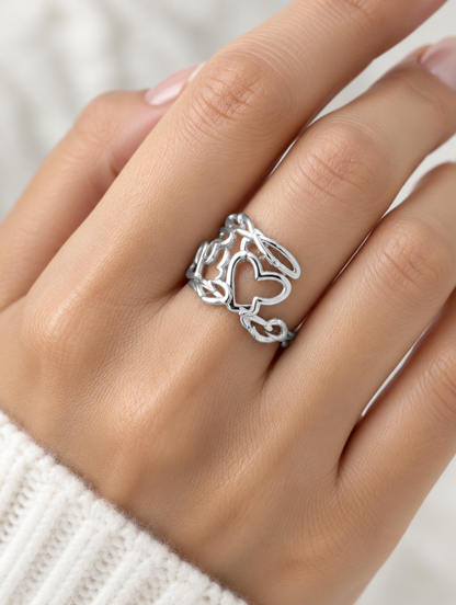 Woman wearing a silver hollow heart outline ring on her finger
