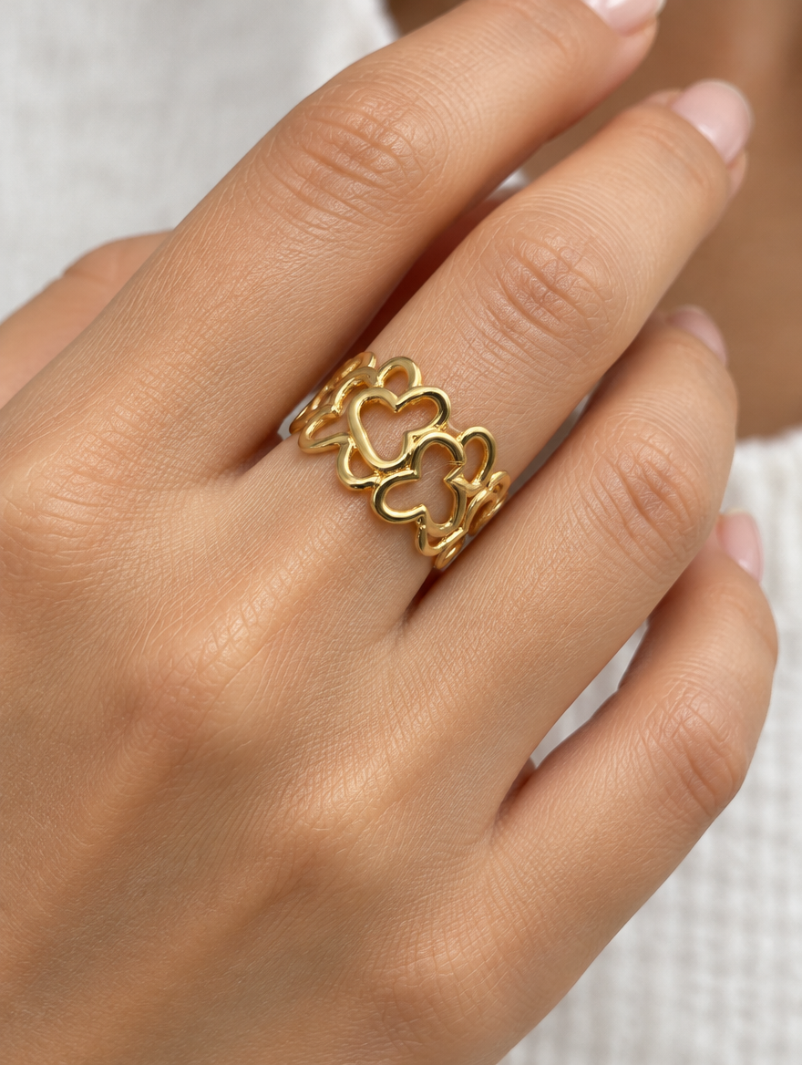 Woman wearing a gold hollow heart outline ring on her finger