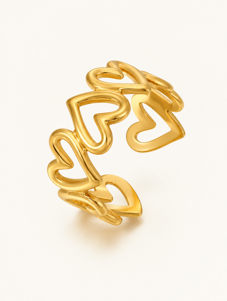 Gold hollow heart outline ring on a neutral background