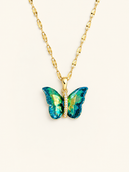 Gold necklace with a blue-green enamel butterfly with a row of tiny crystals on a neutral background
