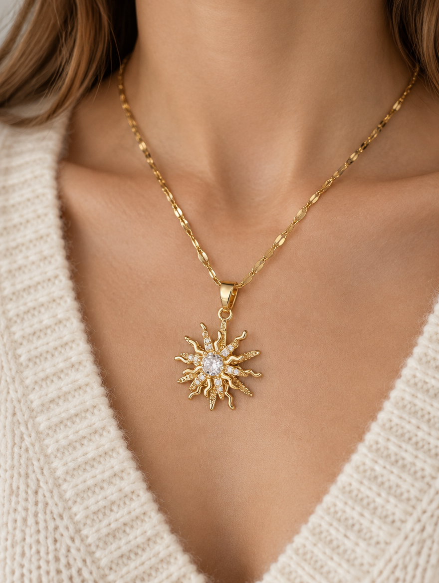 Woman wearing a gold sun pendant necklace with a cream knit sweater