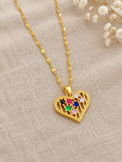 Gold colourful heart pendant necklace lying flat on linen