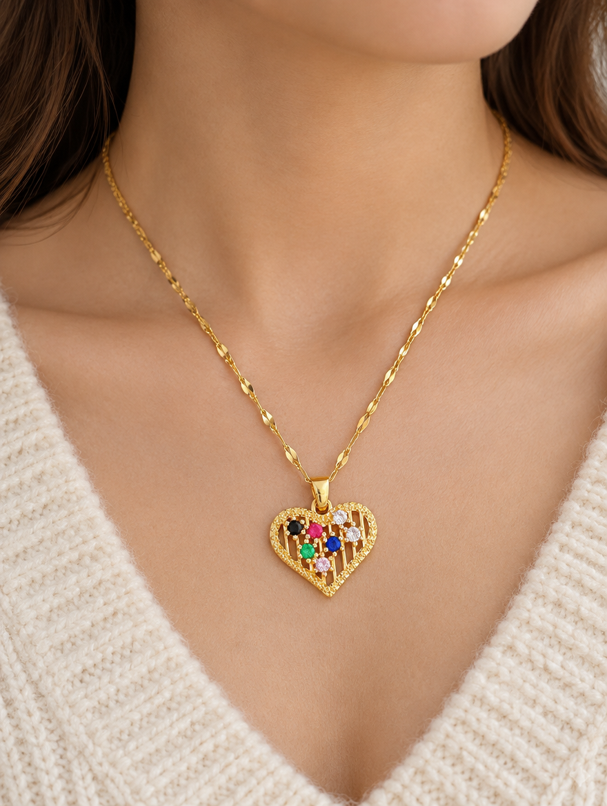 Woman wearing a gold colourful heart pendant necklace with a cream knit sweater
