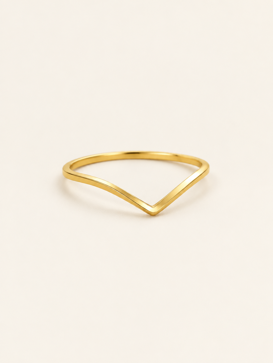 Gold slim chevron band ring on a neutral background