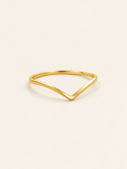 Gold slim chevron band ring on a neutral background