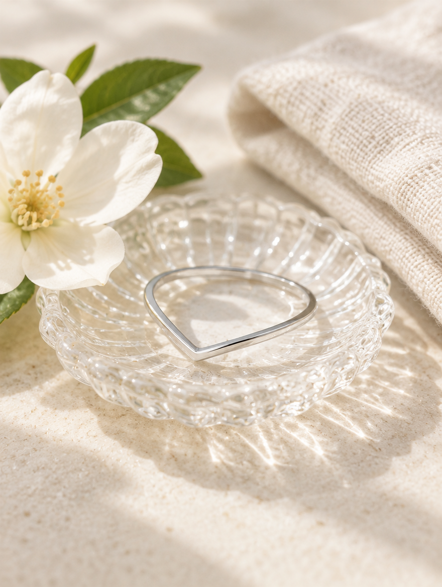 Silver slim chevron band ring in a small dish with styling props