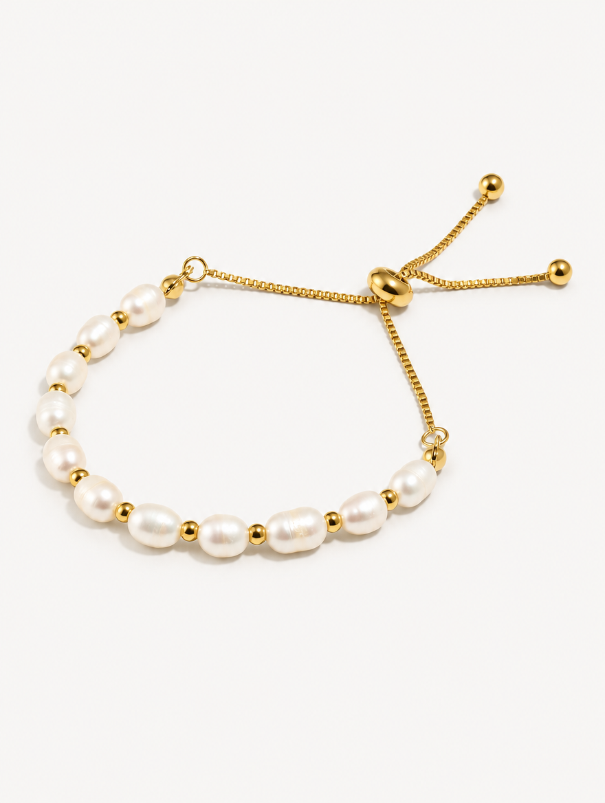 Gold-tone freshwater pearl slider bracelet on a neutral background