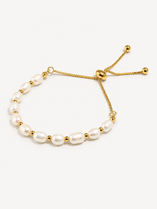 Gold-tone freshwater pearl slider bracelet on a neutral background