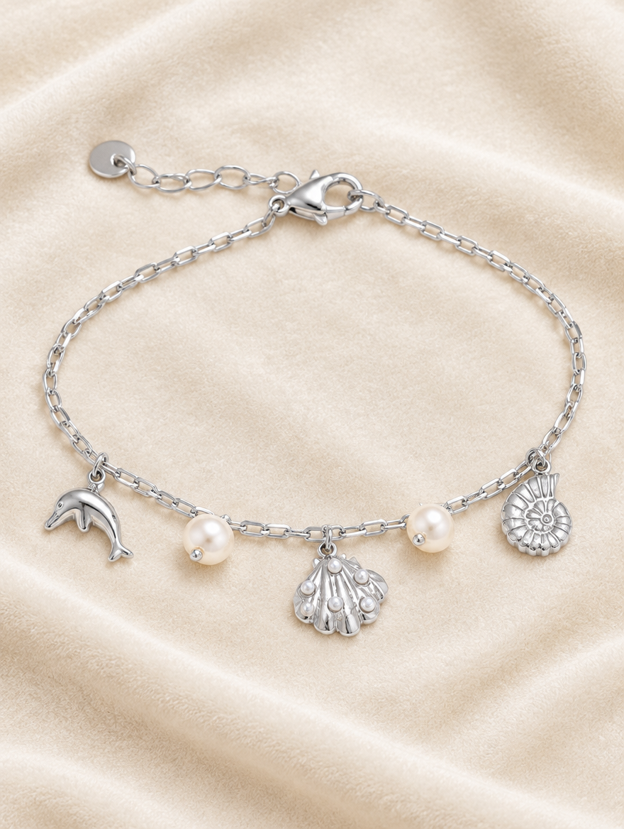 Silver-tone ocean charm bracelet on cream velvet