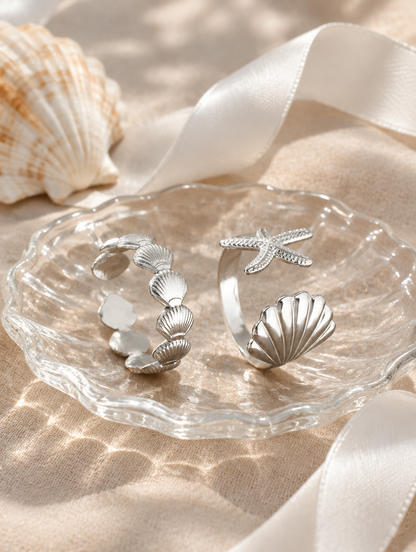 Set of two silver shell and starfish rings in a small dish with styling props
