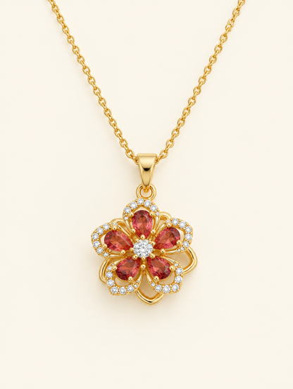 Gold necklace with a flower with red crystal petals on a neutral background