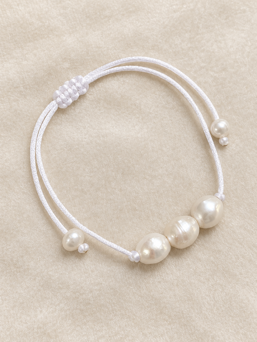 White cord bracelet with baroque freshwater pearls on cream velvet