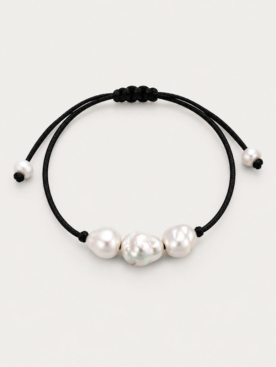 Black cord bracelet with baroque freshwater pearls on a neutral background