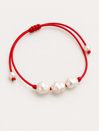 Red cord bracelet with baroque freshwater pearls on a neutral background