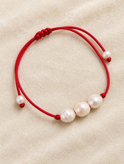 Red cord bracelet with baroque freshwater pearls on cream velvet